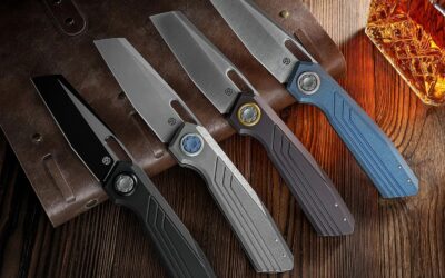 Gruppenaufnahme der vier Vosteed Xeno Varianten (Modell A3801) mit Titangriffen und Vanax-Klingen in verschiedenen Finishes: Black Ti-PVD, Dim Gray Acid Wash, Dark Reddish Purple und Blue.